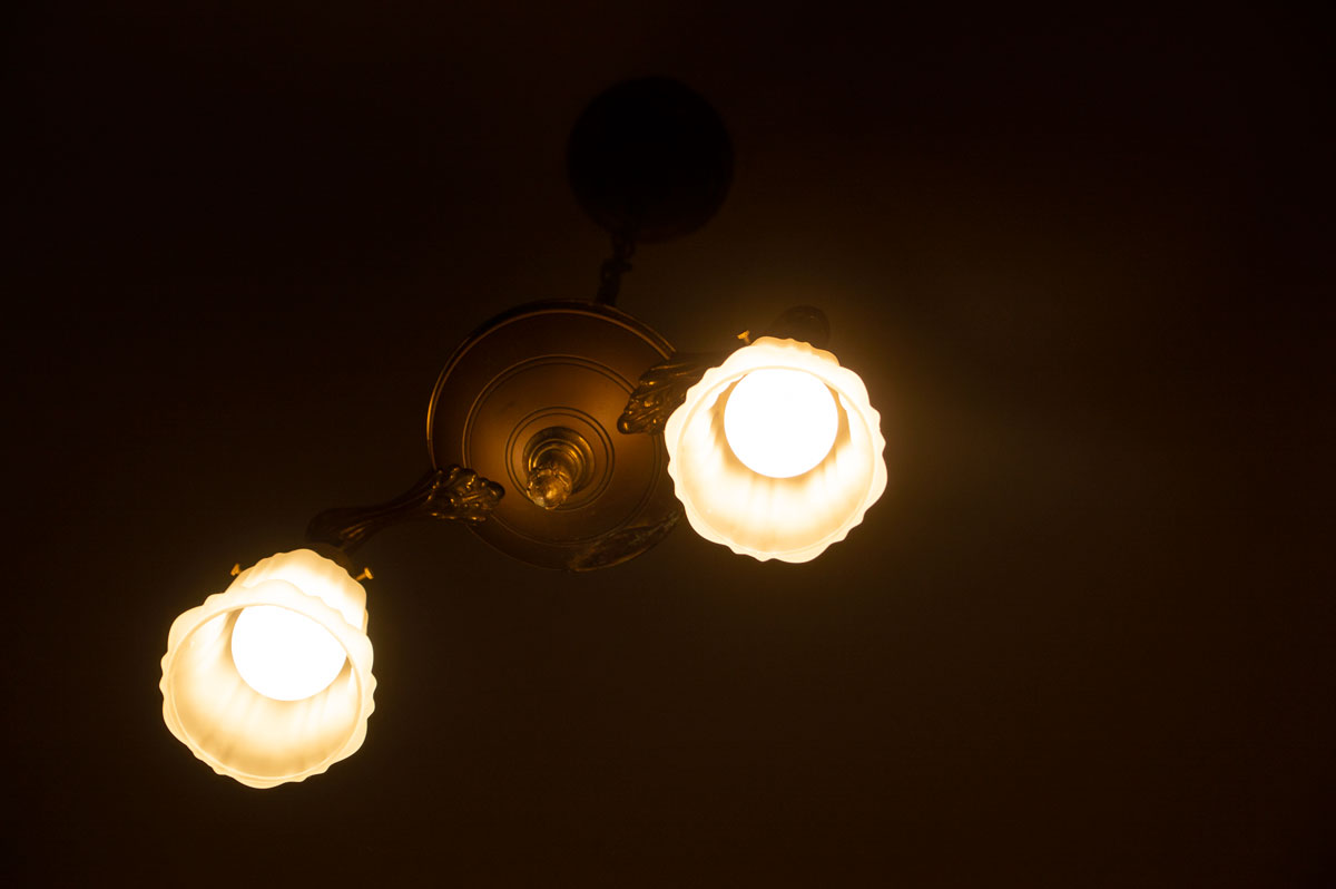 1920s brass pan light with frosted globes retrofitted with soft white LED light bulbs.