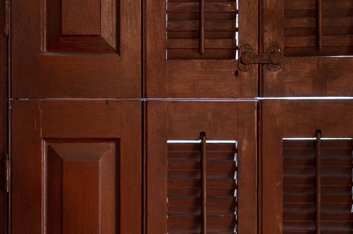 Interior louvered wood shutters closed to keep the sunlight and heat out.