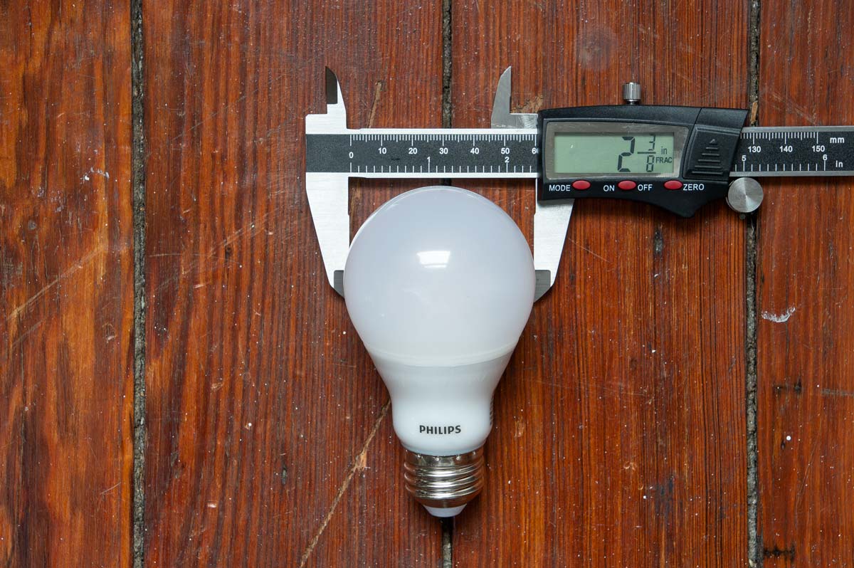 LED bulb with a digital caliper showing the width of an A19 bulb.